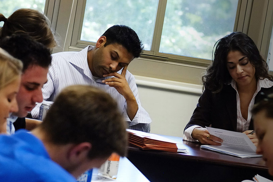 Students sit with their eyes on the work on the table in front of them