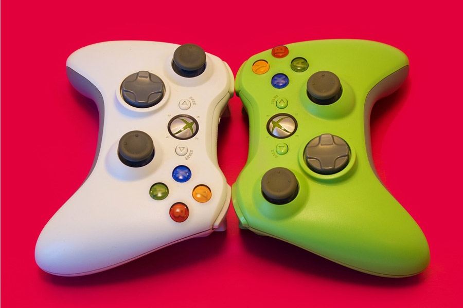 Two video game controllers face each other on a red background.