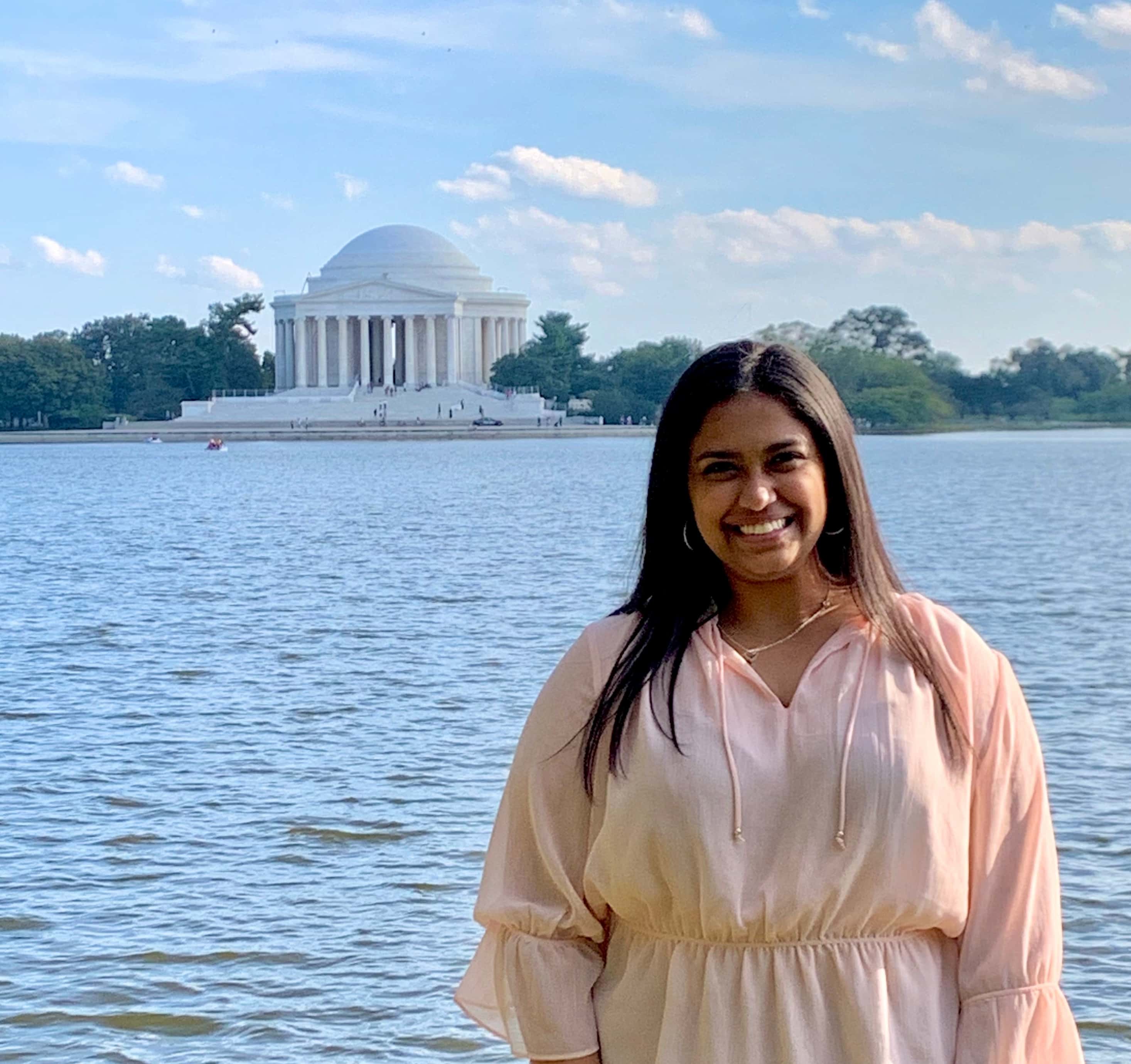 Photo of Tanishka in a pink blouse standing in front of the Tidal Basin