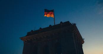 German flag flying with blue sky in the background