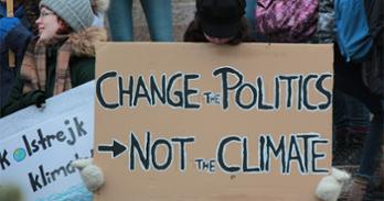 Protest sign reading "Change the Politics, Not the CLimate"