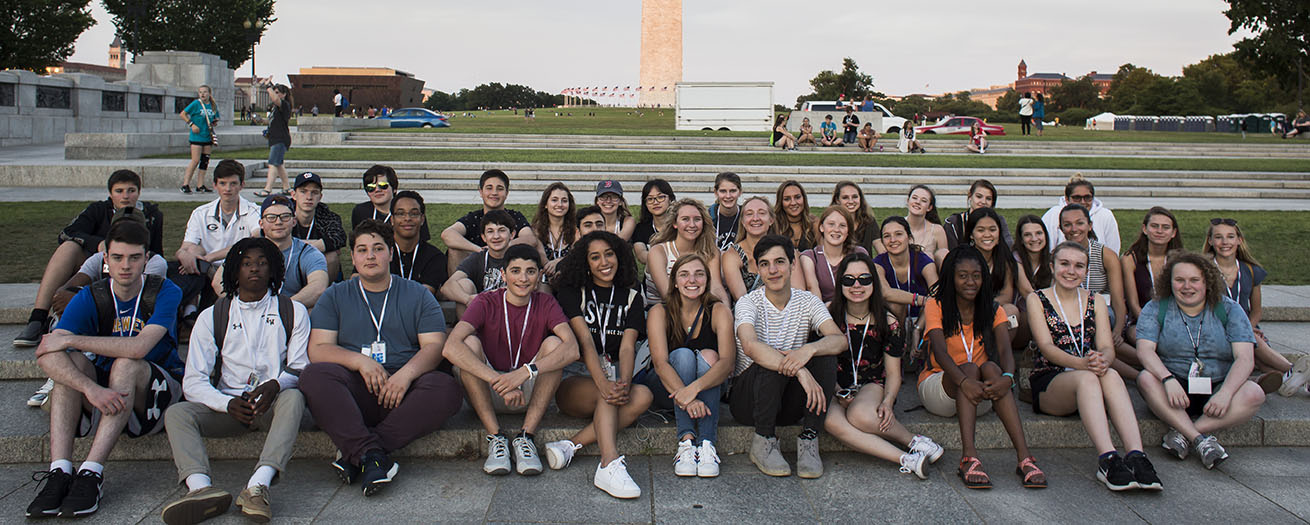 Group shot of discover the world of communication students in front of the Washington monument
