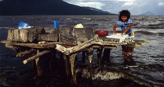 Young girl washes clothing in a lake in Nicaragua