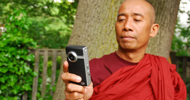 A monk holding a flip camcorder