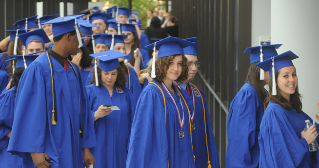 Students in caps and gowns in line at graduation