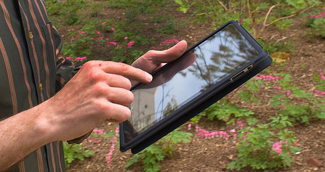 Man using iPad. American University School of Communication's new Digital Media Skills Online Certificate offers courses in mobile development, like iapps