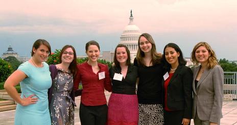 Women standing with the Capitol as background