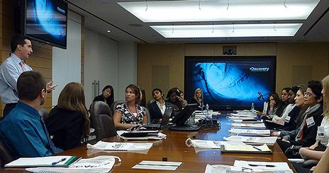 Students meet around a conference table at Discovery Communications.