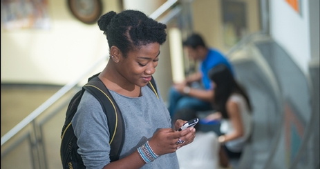 Cover of Annual Report with Student Checking Mobile Device