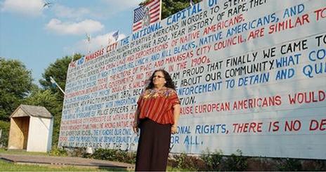 SOC Unseen and Unheard woman in front of sign 2