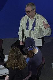 Photo of a man speaking to the participants of a panel discussion