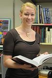 Picture of woman holding a book in front of a shelf of books
