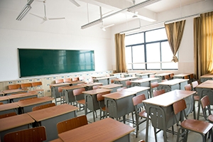 Empty classroom with chairs, desks and chalkboard.