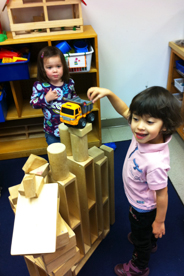 Girls playing making a tower out of blocks
