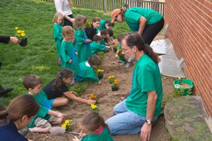 Children planting flowers during Campus Beautification Day