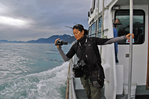 Arlene Agulto, one of twelve students who traveled to Alaska, films whales from a boat. Photo by Lauren Demko