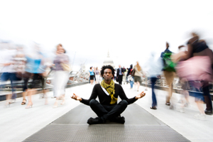 Man meditates in a crowded space