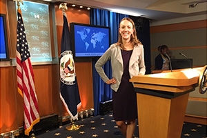 Journalism graduate student Shaun Conway Courtney stands at a podium in the State Department.