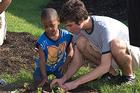 Photo: Anthony Kakoyannis helps a young member of Life Pieces to Masterpieces plant a flower in the new butterfly garden outside the Northeast Washington facility.