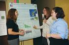 Photo: Jenelle Thomas, SIS, from left, Kate Pinkerton, CAS, and Heather Bauer, CAS, during the lunch time poster presentations at the Honors Capstone.