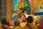 The Dalai Lama in front of a painted religious banner conducts a teaching at American University