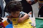 Child creating Tibetan prayer flag