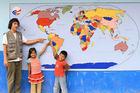Patrick Sullivan '08, his host brother Kevin, and his neighbor Maribel point to Peru on the map Sullivan and students painted on the wall of the new primary school in Silahuá, Peru. (Photo courtesy of Patrick Sullivan)