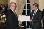 Jack Rasmussen, left, receives the Knight’s Cross of the Order of Merit from the ambassador of Hungary, Bela Szombati.