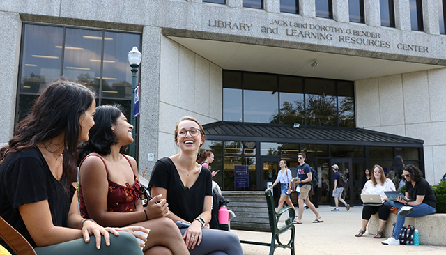 Students sitting on bench in front of AU's Bender Library.