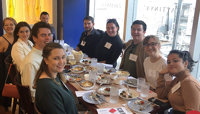 Young alumni sitting around table