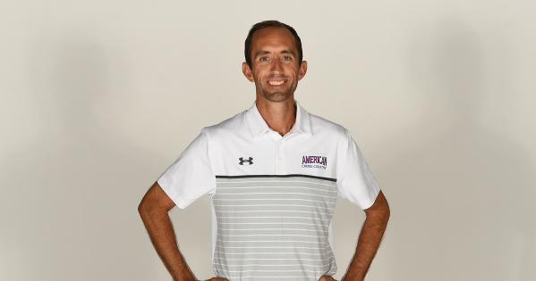 Headshot of Sean Graham, American University’s Track and Cross Country head coach and a member of the AU alumni board, wearing a striped polo shirt with the AU logo.