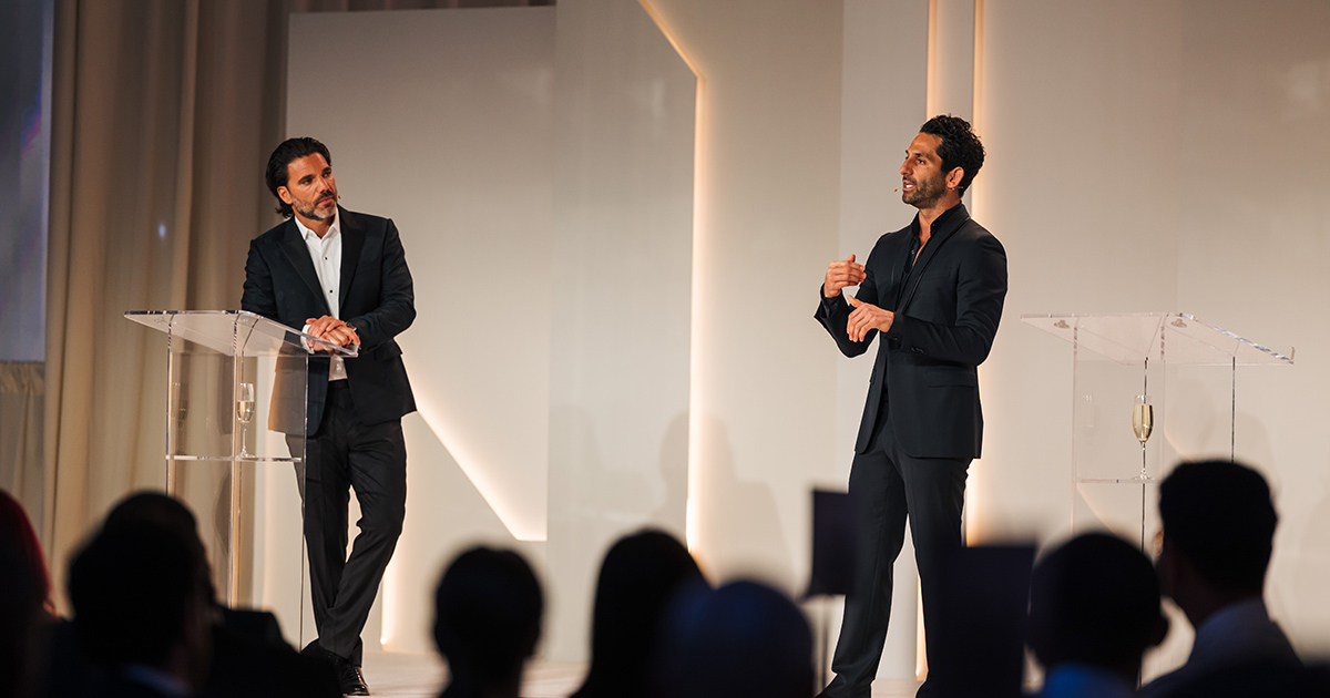 Asher Raphael and Corey Schiller on stage in front of a crowd of people