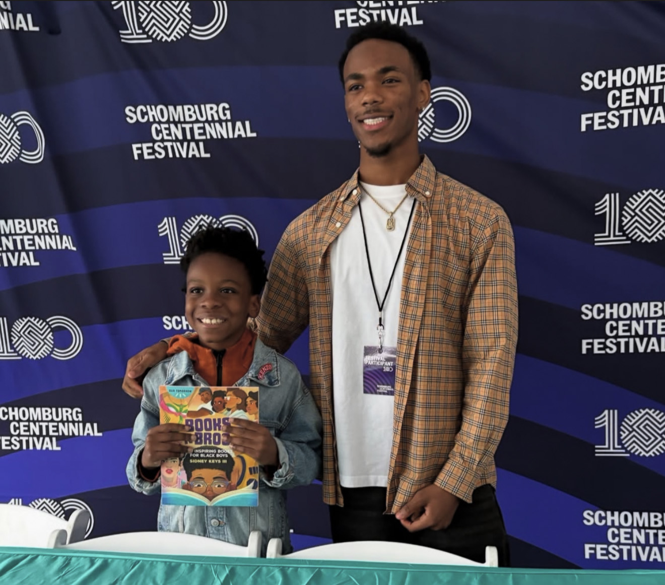 Keys poses with a young reader at a book signing.