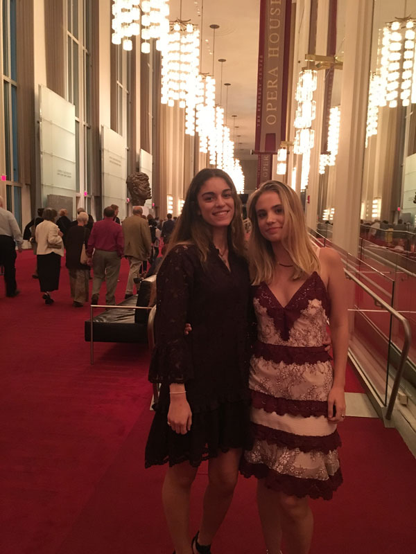 Two young women in a high-ceilinged lobby