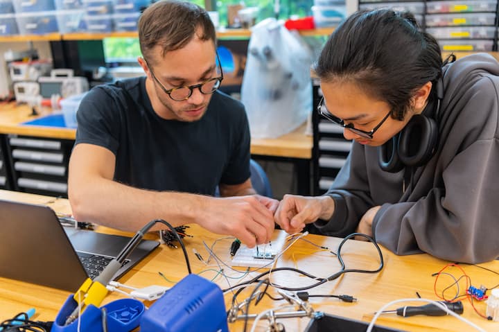 Student assembling circuitry on board they designed and cut.