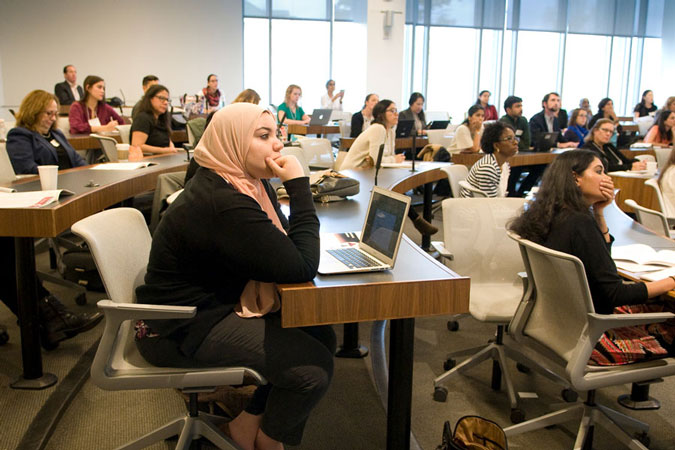 Audience sitting at desks with laptops