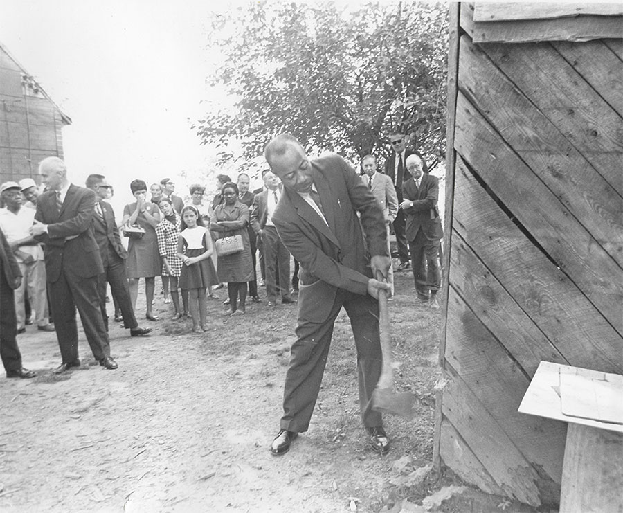 A man swings an axe at a structure