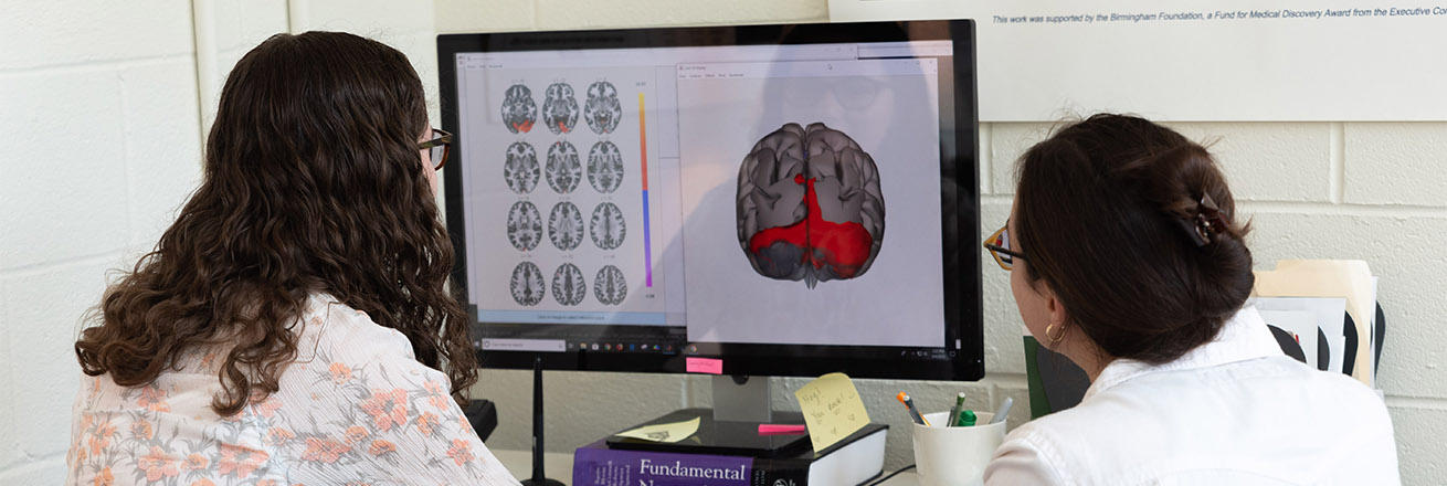 Two neuroscience students look at imaging of brains on the computer