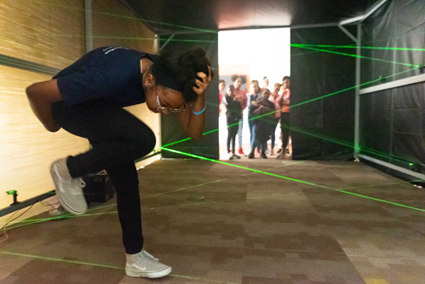 Visiting students climb through a laser maze at AU Physics Department