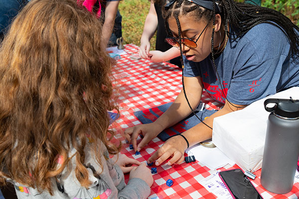 An AU math student shows a elementary student multi-sided dice