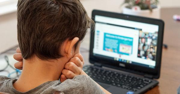 A young student learning remotely using a laptop