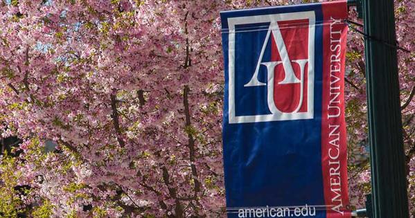 AU pennant in front of cherry blossom trees