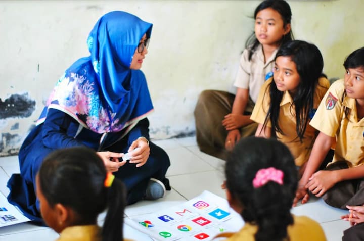 Woman in hijab teaching; credit: Husniati Salma, Unsplash.