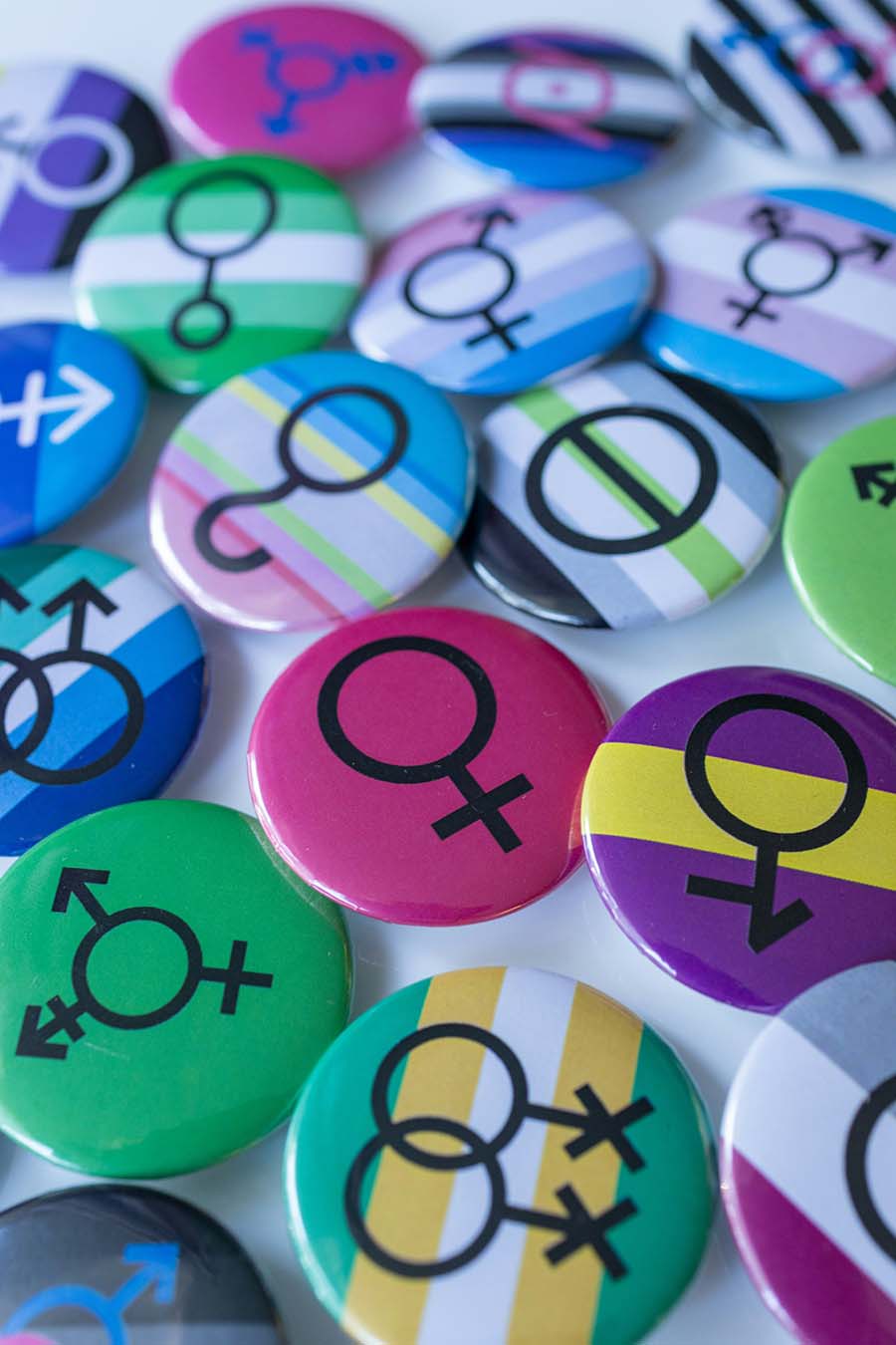 Assortment of gender symbol and pride flag buttons. Credit: Marek Stuzinski
