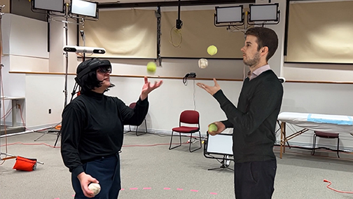 a person with an augemented reality headset juggles with the guidance of a hologram