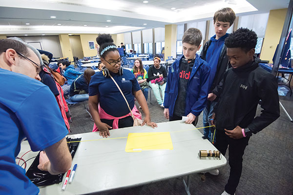 Group of young students doing a physics experiment