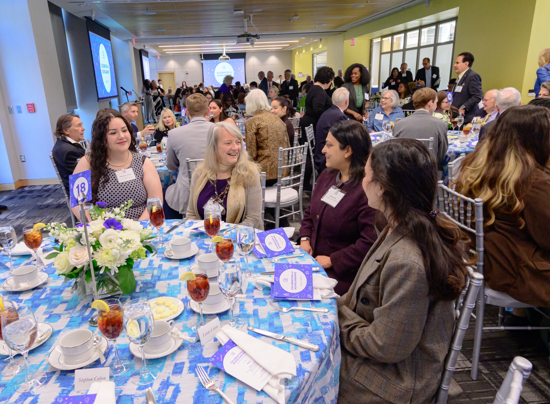 Students and donors smiling together at a table.