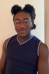 AU Student, Kwesi, wearing a black tank top, smiling at the camera