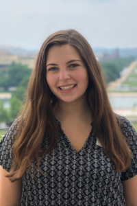 AU Student, Marley, standing in front of the Washington Monument, wearing a blue blouse