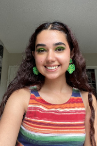 AU Student, Tiba Shlash, smiling at the camera and wearing a striped tank top